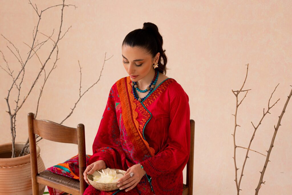 a woman sitting on a chair holding a plate of food.