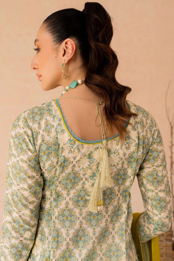 a woman wearing a green and white top with a tassel.