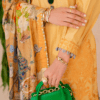 a woman in a yellow dress holding a green purse.